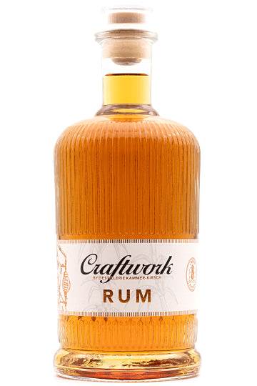 Flasche Rum mit geriffeltem Glas und Korkverschluss, Etikett mit "Craftwork Rum" beschriftet.